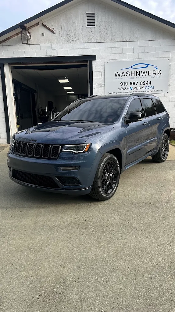 Blue Jeep Grand Cherokee with tinted windows outside the WashNWerk shop
